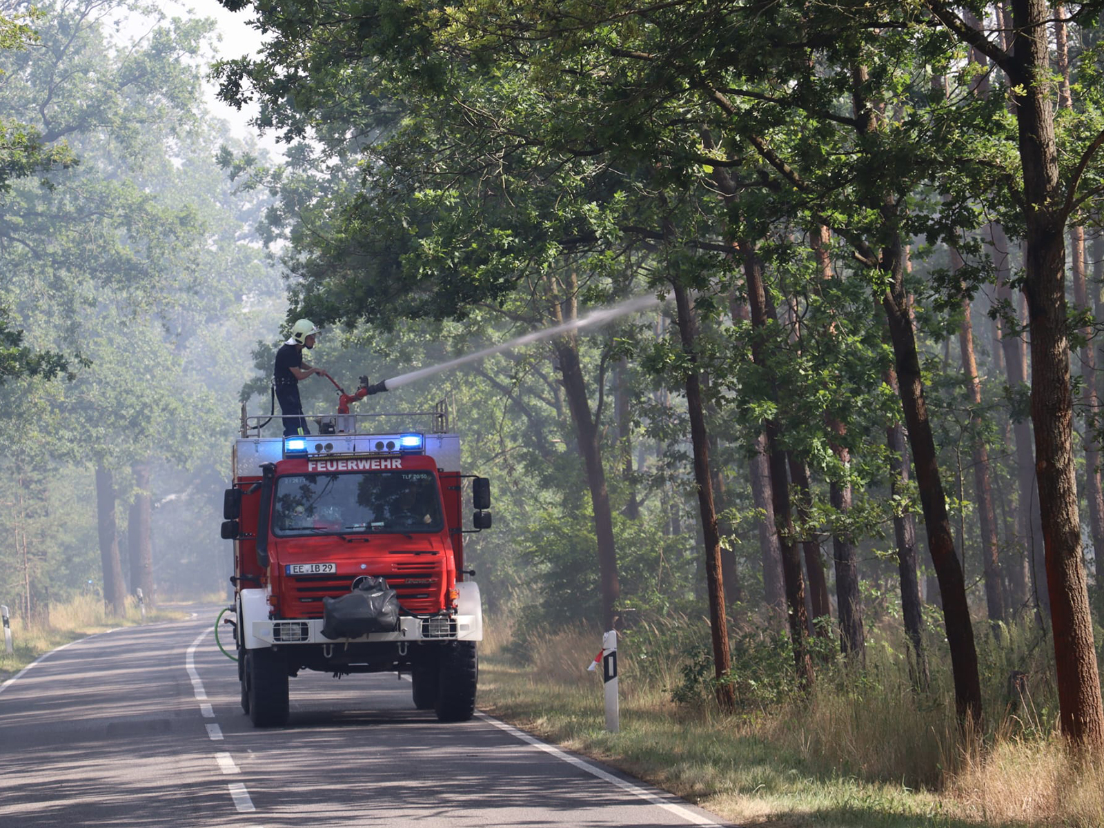 Ein Feuerwehrfahrzeug löscht beim Waldbrand