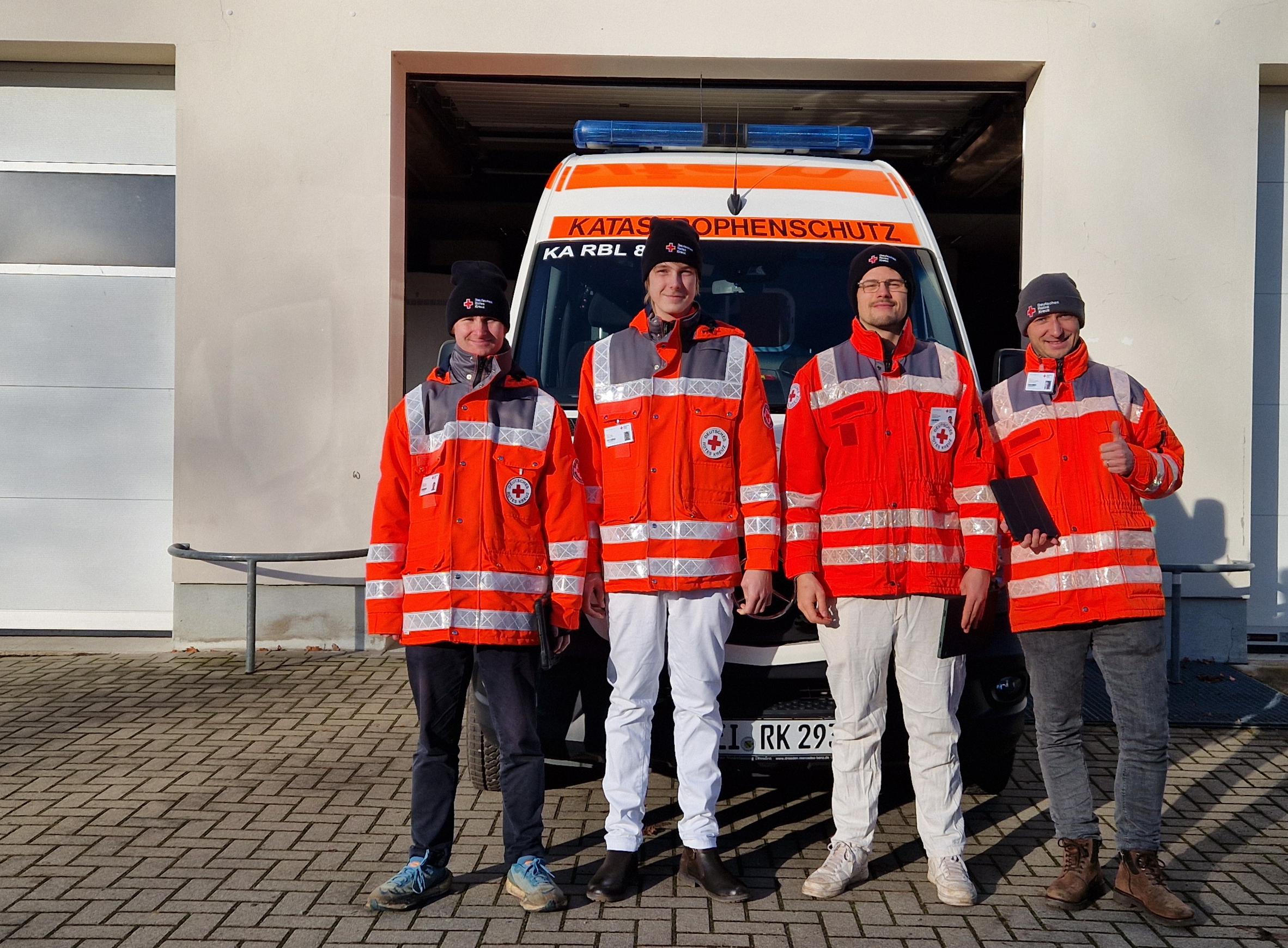 Fördermitgliedwerber in Rotkreuzjacken vor DRK-Einsatzfahrzeug