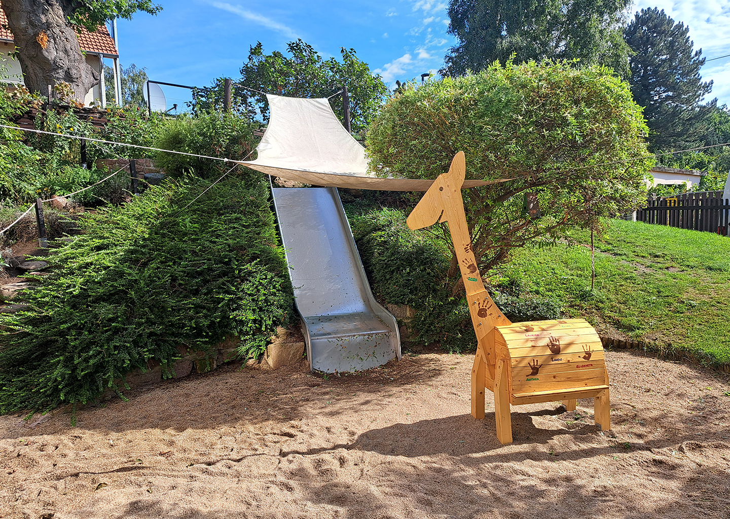 Rutsche mit Holz-Giraffe im Sandkasten