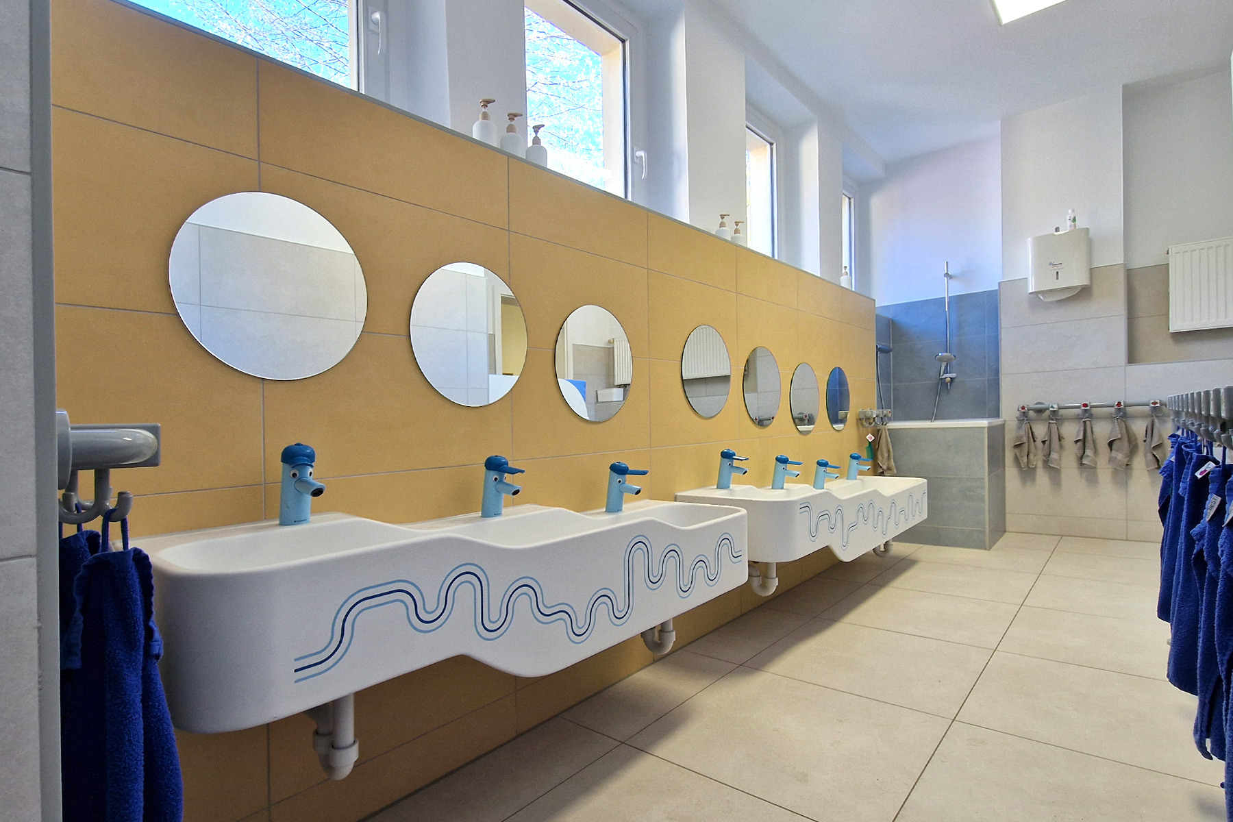 Sanitärbereich für Kinder mit bunten Wasserhähnen und Waschbecken