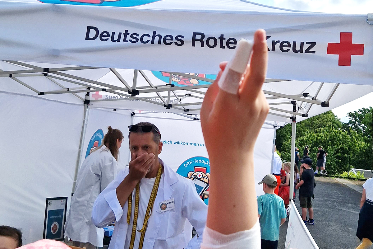 Ein mit einem Pflaster versehener Finger meldet sich