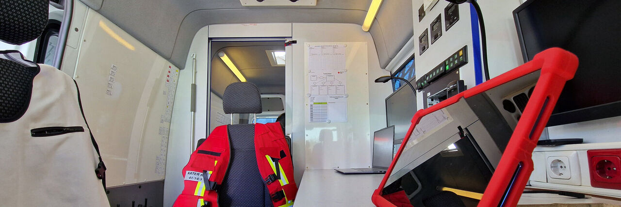Innenraum Einsatzleitwagen mit Monitoren, Tablet und Funkgeräten