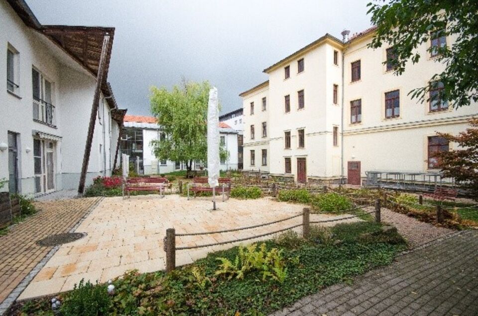 Innenhof des Seniorenpflegeheims mit Sitzbänken