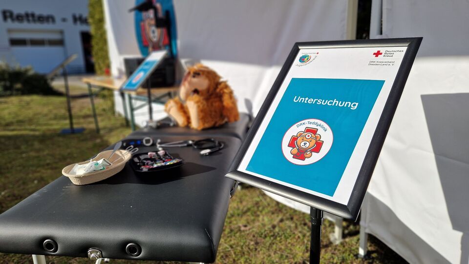 Infoständer Untersuchung mit Untersuchungsliege, Plüschtier und Untersuchungsutensilien